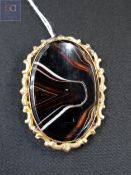 YELLOW METAL BROOCH WITH AGATE STONE
