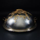 A large round metal and gilt metal meat dish and cover