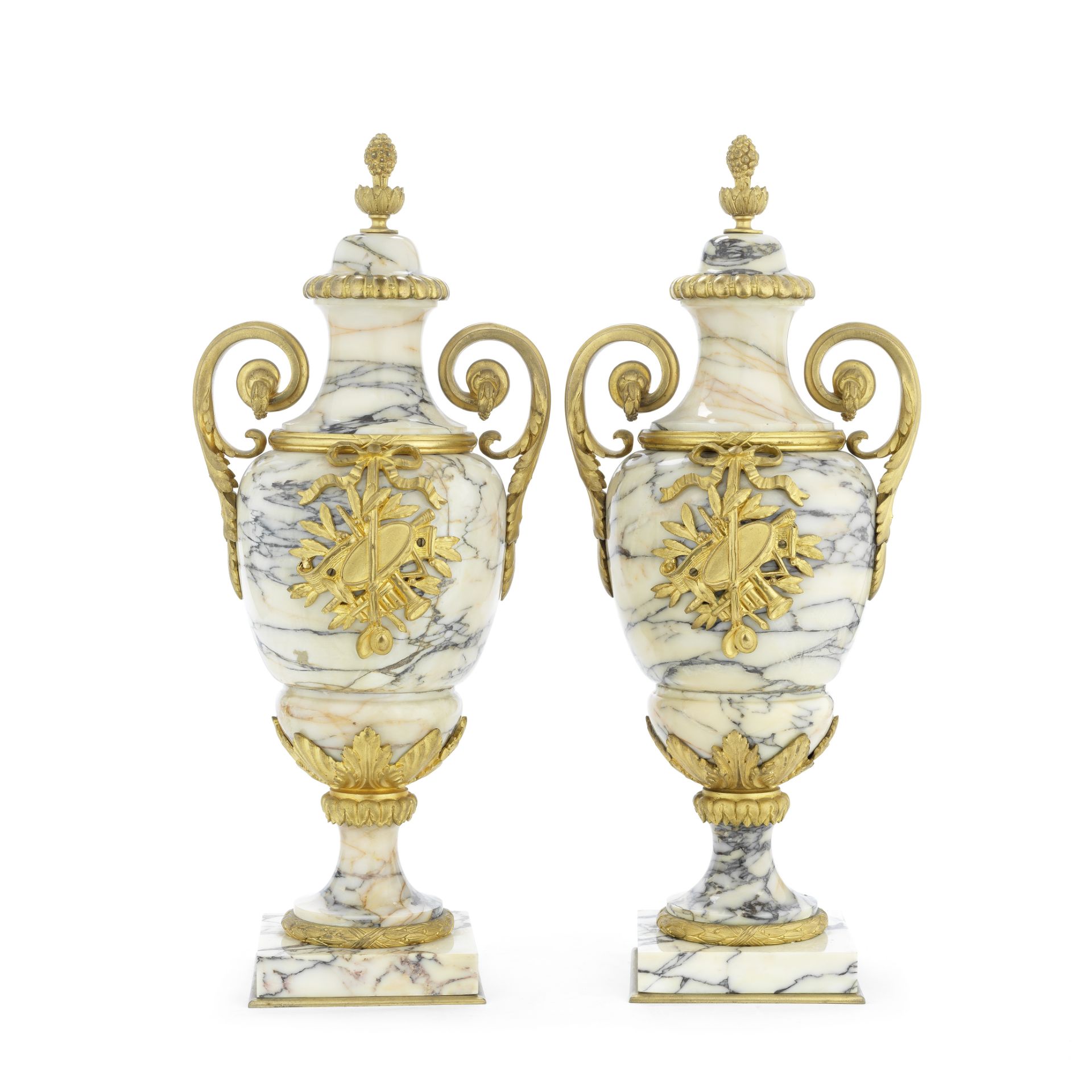 A pair of gilt bronze mounted cream veined marble garniture urns in the Louis XVI style, probabl...