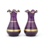 A pair of small gilt decorated amethyst glass vases