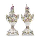 A pair of late 19th century/early 20th century floral encrusted Continental porcelain garniture v...