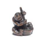 A WOOD NETSUKE OF AN ONI (DEMON) WITH A MORTAR AND PESTLE By Ittan, Nagoya, Edo period (1615-1868...