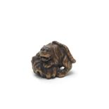 A WOOD NETSUKE OF A TIGER ON A ROCK By Kokei, Kuwana, Ise Province, Edo period (1615-1868), early...