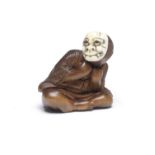 A WOOD NETSUKE OF A BOY WITH AN ONI (DEMON) MASK By Hojitsu, Edo period (1615-1868), mid 19th cen...