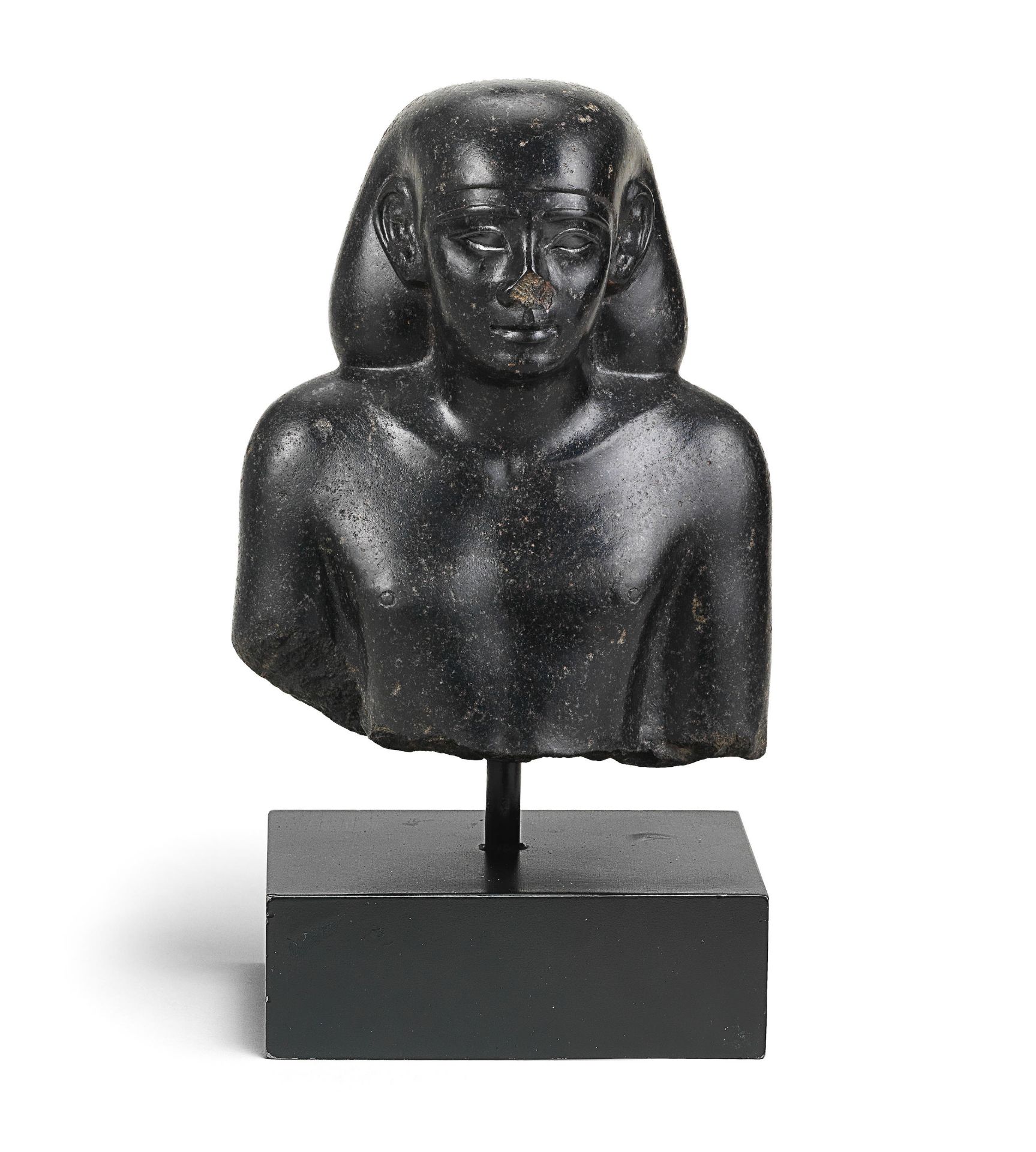 An Egyptian basalt bust of an official and priest for Wedja-Hoor-mehnet