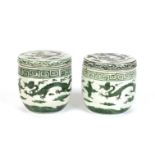 TWO CHINESE GREEN GROUND CYLINDRICAL JARS AND COVERS
