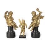 A pair of gilt bronze figures of seated classical draped putti and a gilt bronze figure of a wing...