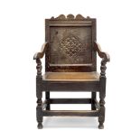 A 17th century oak panel back armchair