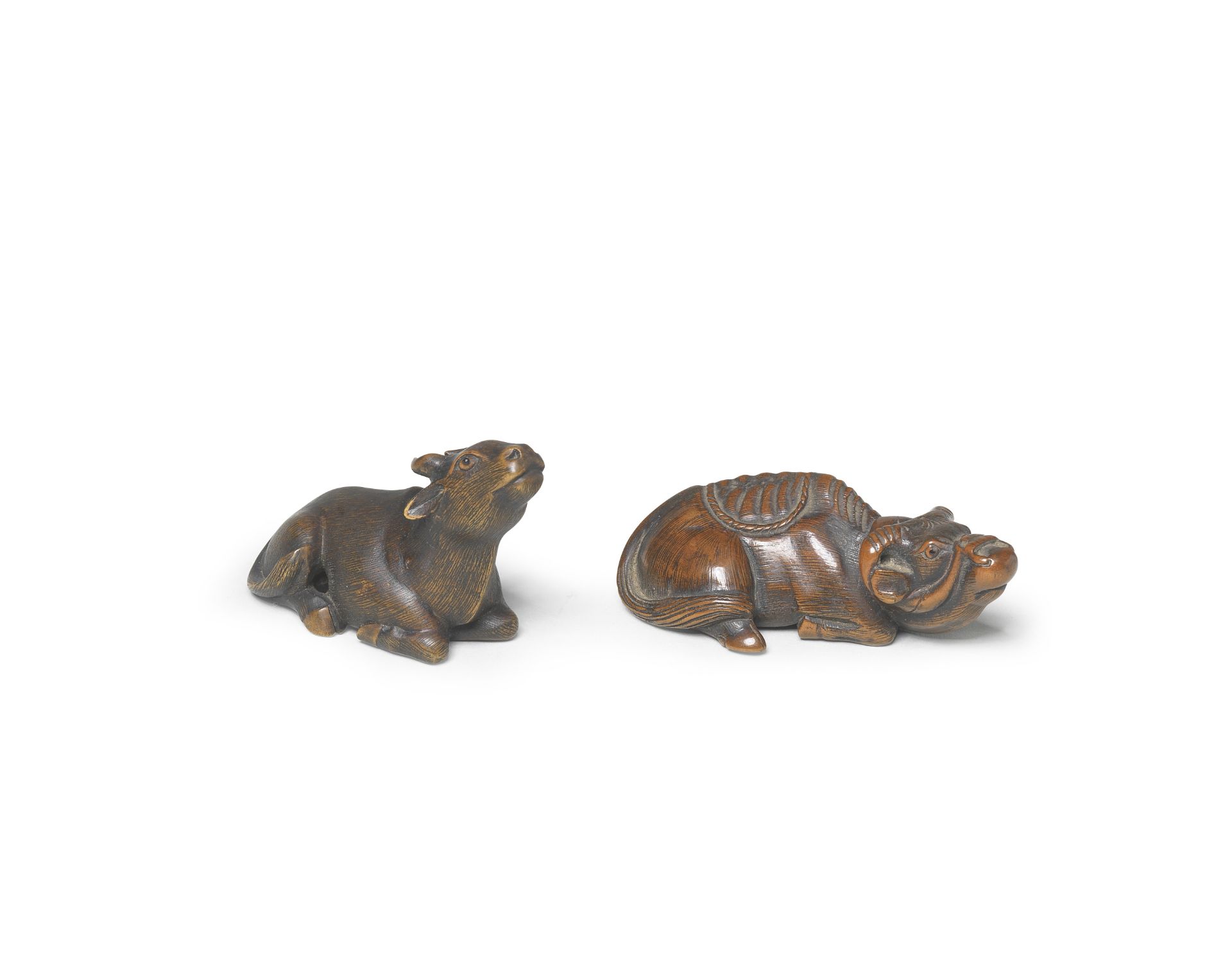 TWO WOOD NETSUKE OF RECUMBENT OXEN Edo period (1615-1868) to Meiji era (1868-1912), 19th century (2)