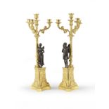 PAIRE DE CANDELABRES LOUIS-PHILIPPE EN BRONZE DORE ET BRONZE PATINE A TROIS BRAS DE LUMIERES DEU...