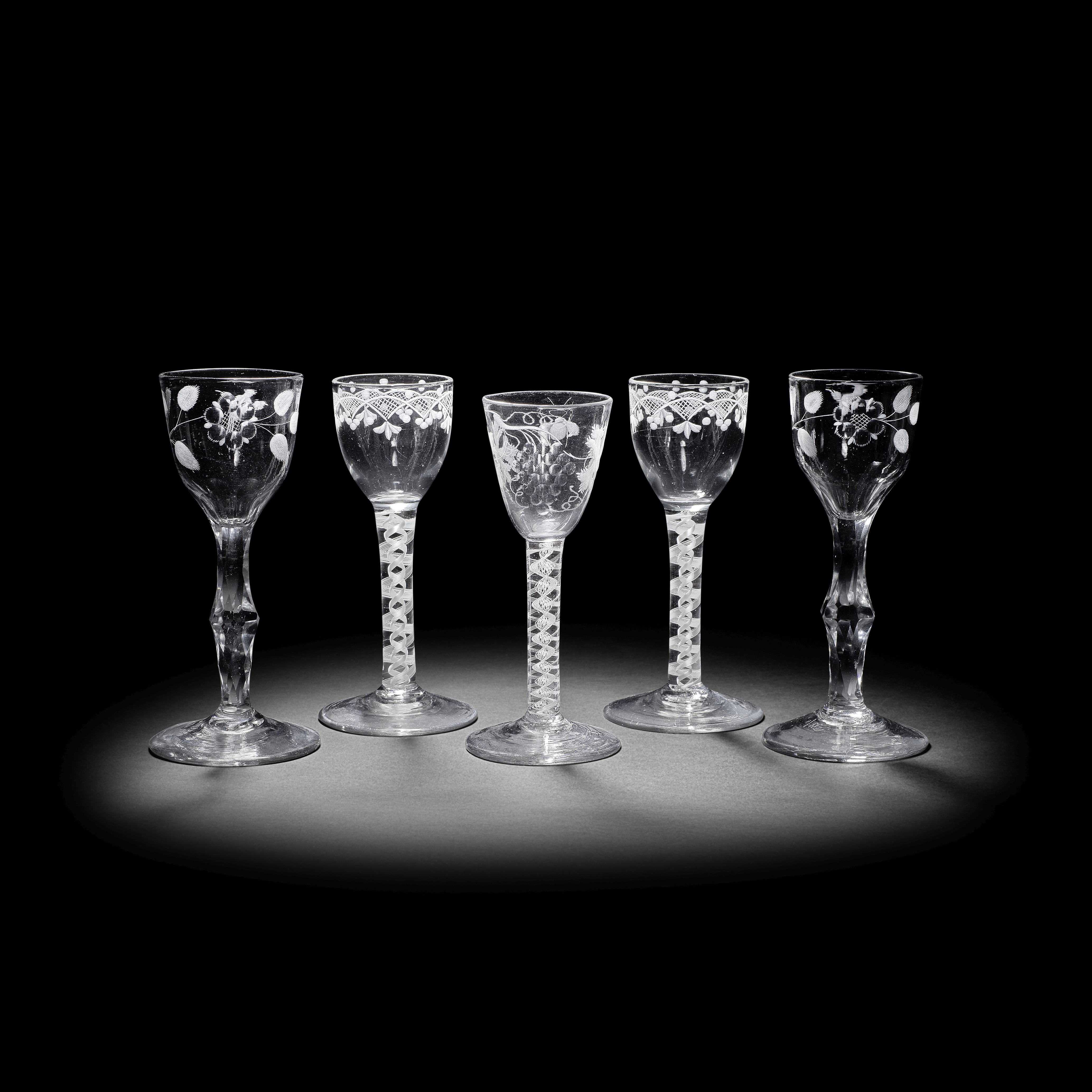 Three engraved opaque twist wine glasses and a pair of facet stem glasses of possible Jacobite si...