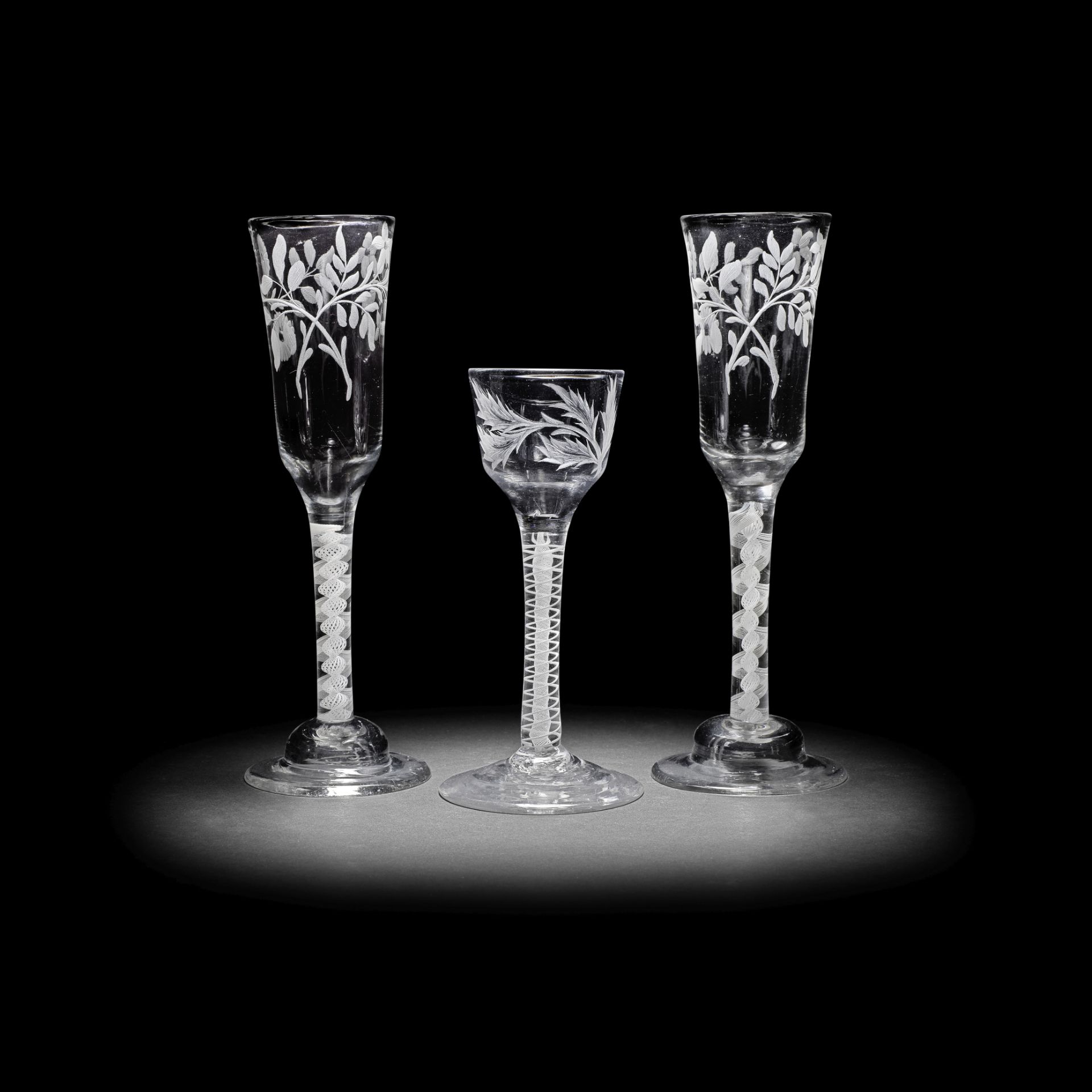 A pair of engraved opaque twist ale flutes and a wine glass, circa 1765