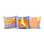 A set of three cushions, the covers featuring designs by Sir Peter Blake, Richard Smith and Allen...