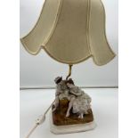 An early 20th century porcelain group figurine table lamp.