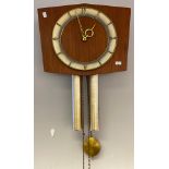 A Mid century teak wall clock with weights and pendulum.