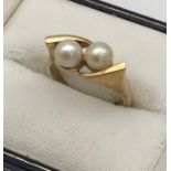 A Ladies 9ct yellow gold and two pearl set ring. [Ring size] [3.82Grams]