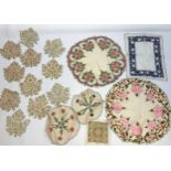 A Collection of vintage hand embroidery doilies in the shape of maple leaves and floral design tabl