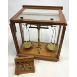 Philip Harris Ltd Birmingham scales within a fitted wood and glass cabinet.