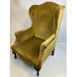 Victorian gull wing chair with cushioned arm supports and seat, upholstered in a green material