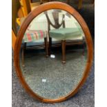 An Edwardian oval framed and bevel edge mirror
