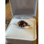 A Gent's 9ct yellow gold ring set with a single garnet stone. [Ring size N] [4.68Grams]