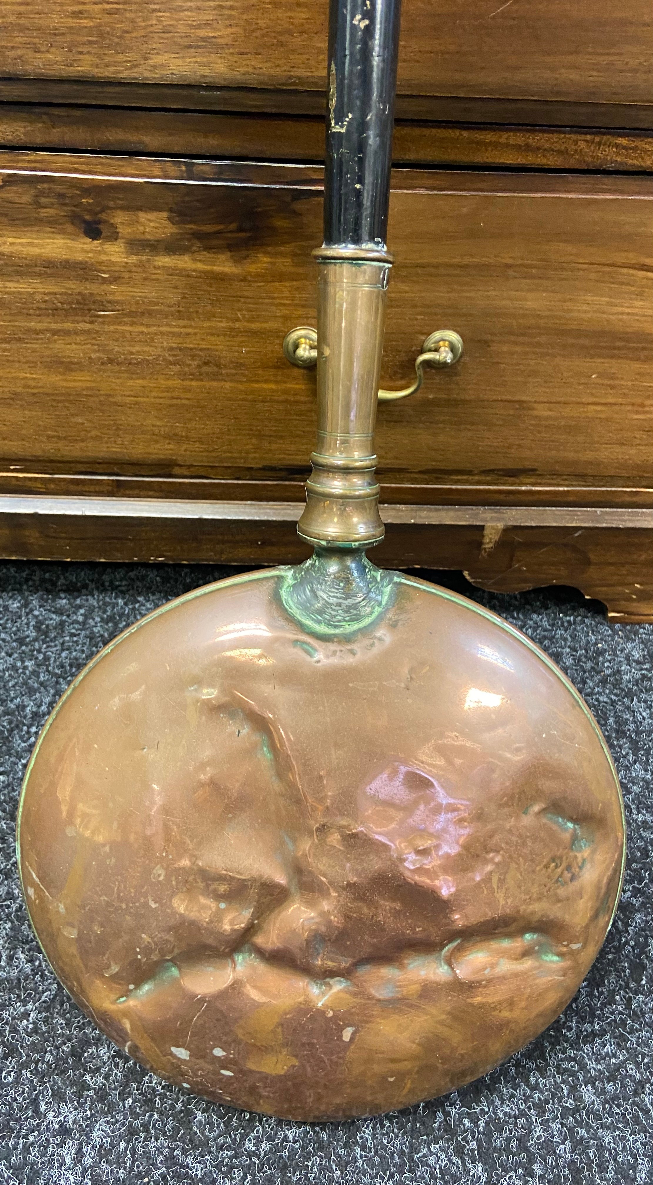 A 19th century copper bed warmer.