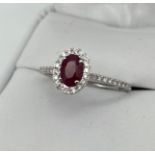 An 18ct white gold ruby and diamond ring. [Ring size O]