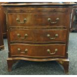 Georgian style serpentine chest, the top with a moulded edge above a pull-out ledge, leading to a