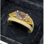 A ladies 9ct yellow gold three stone ring, Brown Smokey centre stone with two citrine style shoulder