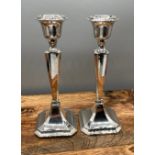 A Pair of Chester silver candle sticks produced by Clark & Sewell. [18cm in height] [one as found]