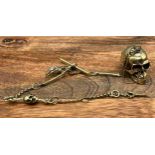 An unusual brass albert style skull watch chain. [30cm in length]