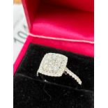 A 9ct white gold diamond cluster ring of 1.1cts. [Ring size M] [3.74grams]