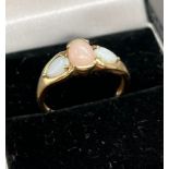 A Ladies 9ct yellow gold ring set with a centre pink opal and off set by two white opals to the