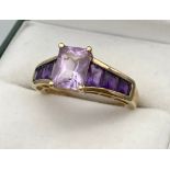 A Ladies 9ct yellow gold ring set with purple cut stones. [Ring size N] [3.02Grams]