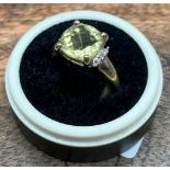 A Ladies 9ct yellow gold ring set with a large pale yellow stone off set by diamonds to each