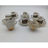 Set of six porcelain cups and saucers in a floral design, within marked London silver holders [