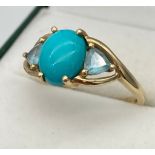 A Ladies 9ct yellow gold ring set with a large Turquoise centre stone, off set by two aqua