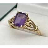 A Ladies 9ct yellow gold ring set with a single purple cut stone. [Ring size N] [1.96Grams]