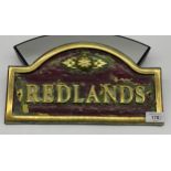 CAST AND PAINTED HOUSE NAME SIGN, 'REDLANDS', 34cm wide, along with four gilded wall plaques