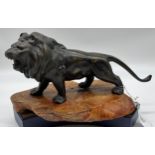 A Large Bronze lion sculpture sat upon a wooden stand. [34cm in length]