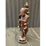 A large 19th century Chinese Root wood hand carved monk style figure holding a bird, table lamp. [