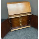 Antique Light oak writing bureau, designed with double door base section to reveal a multi drawer