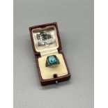 A Ladies Silver Art Deco Ring set with a large blue aquamarine style stone surrounded by marcasite