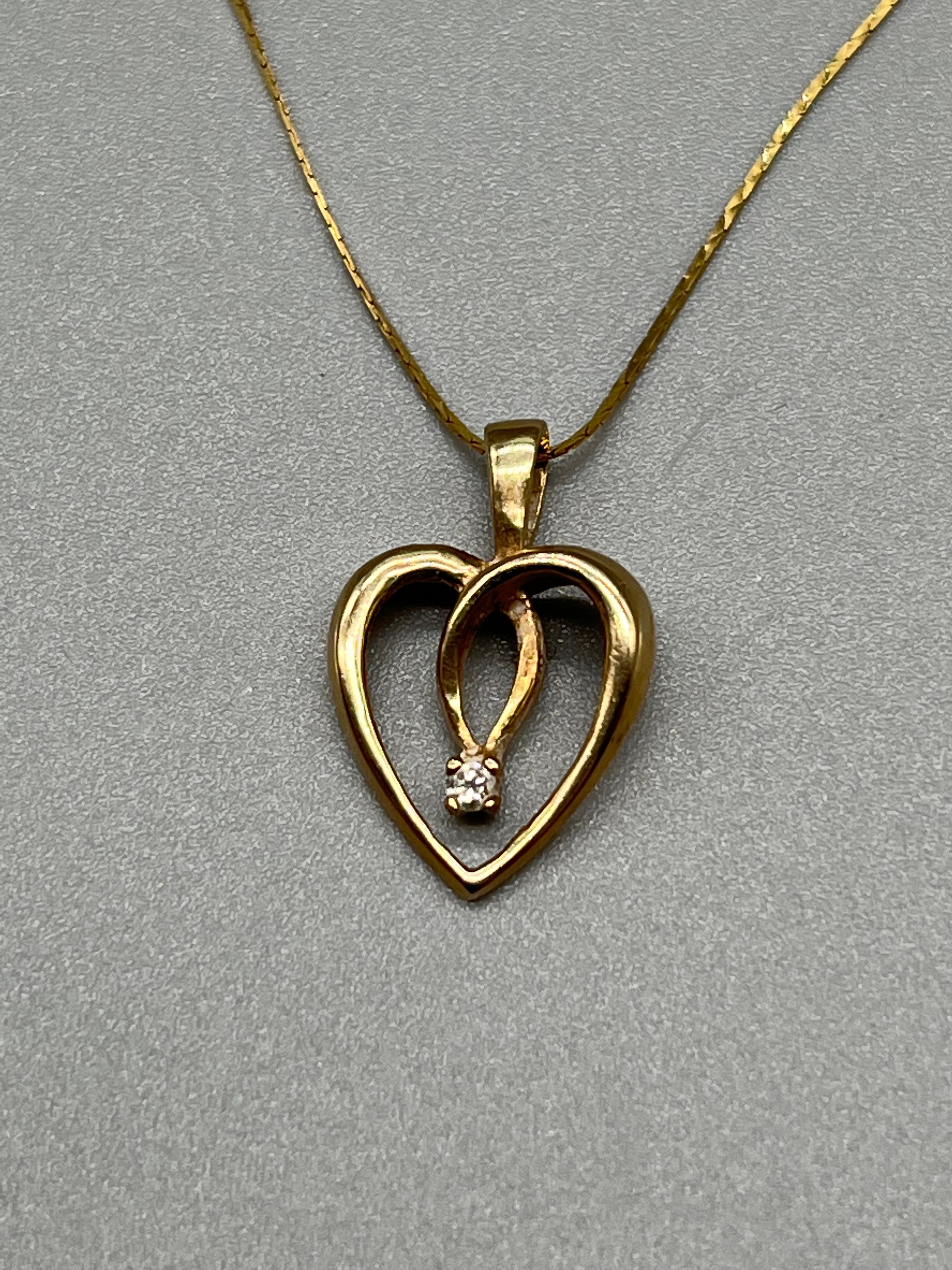 A 9ct gold heart shaped pendant set with a single diamond and comes with a 9ct gold necklace. [1. - Image 2 of 3