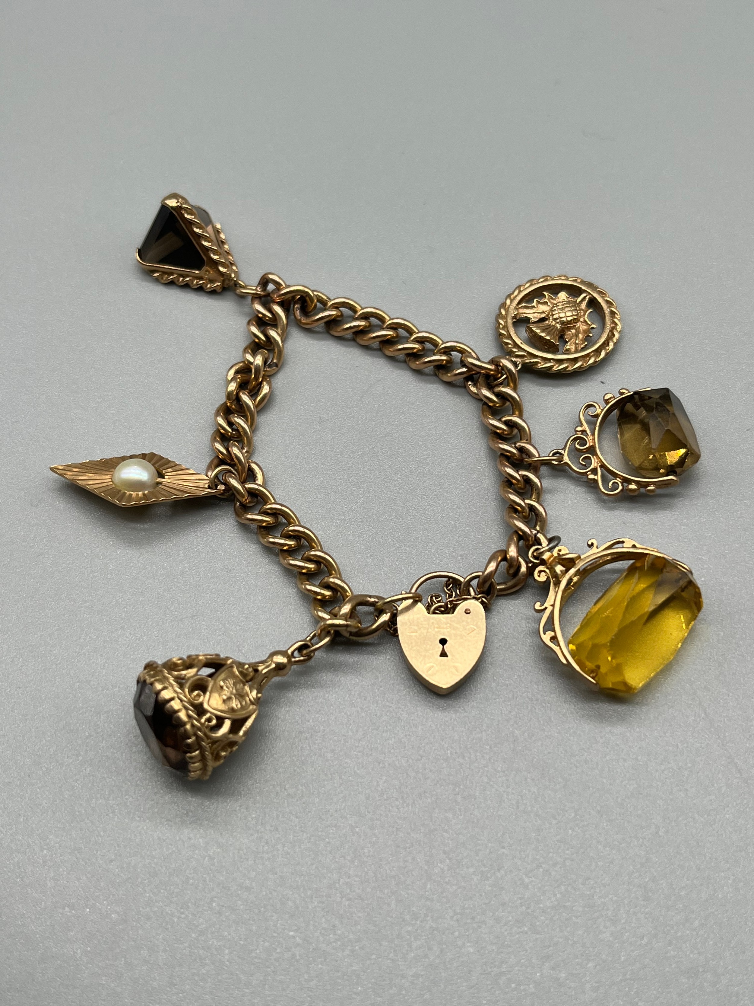 A 9ct gold charm bracelet, attached with various fob charms. [43.04grams]