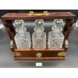 A Vintage tantalus containing three cut crystal decanters. Comes with key.