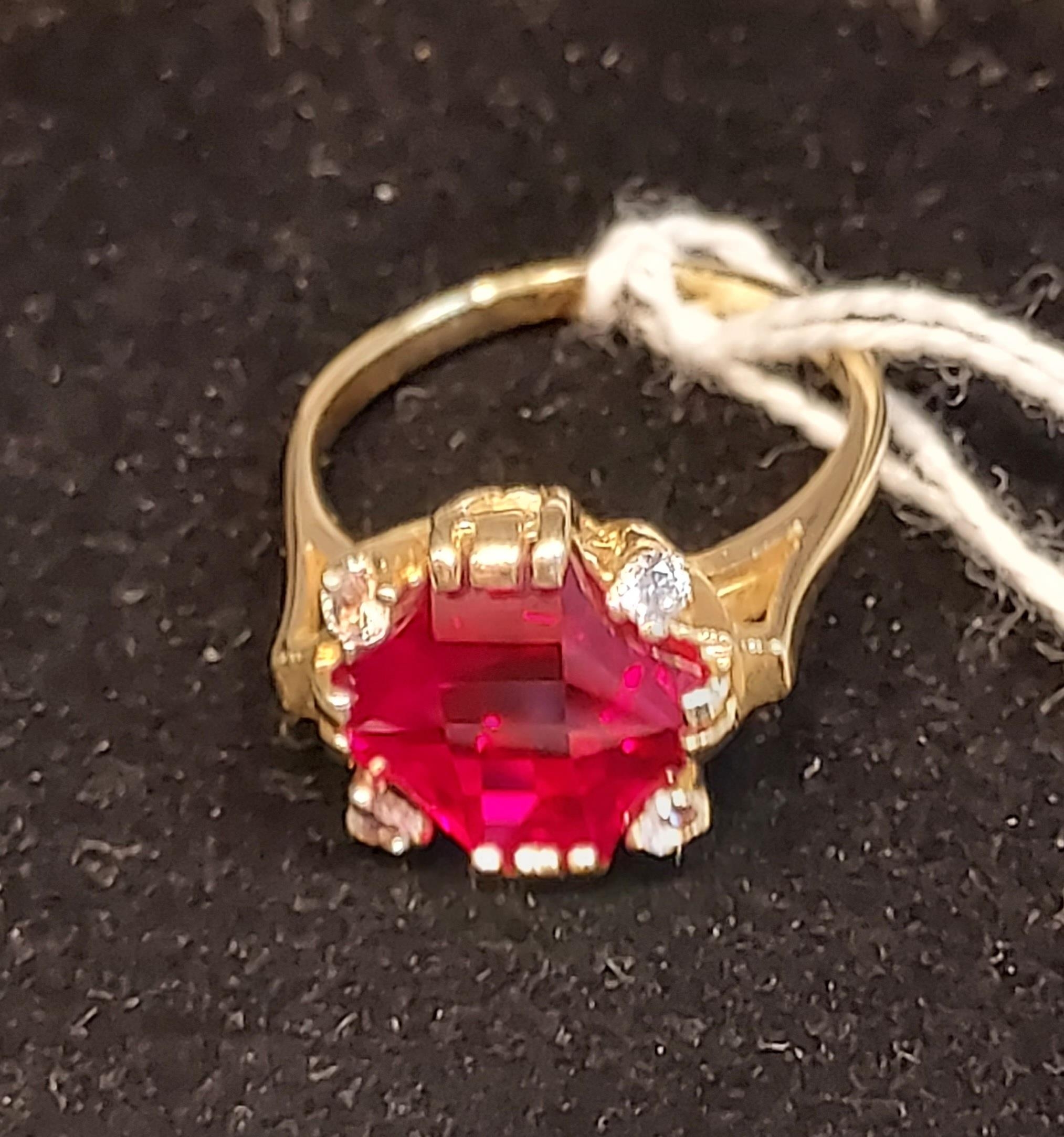 A 14ct yellow gold ring set with a large cut single ruby and four white spinel stones. [Ring size R] - Image 2 of 3