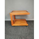 A Mid century teak two tier side table, Supported on castors. [60x66x52cm]
