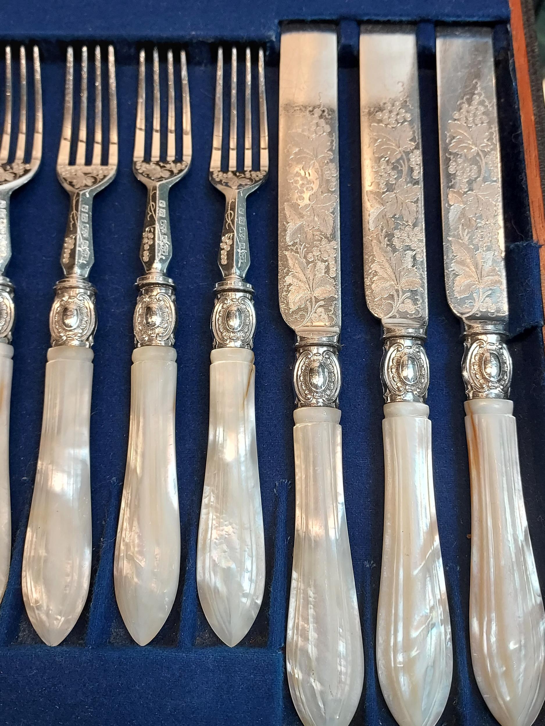 A Boxed set of twelve ornate knives and forks, designed with mother of pearl handles. - Image 2 of 3