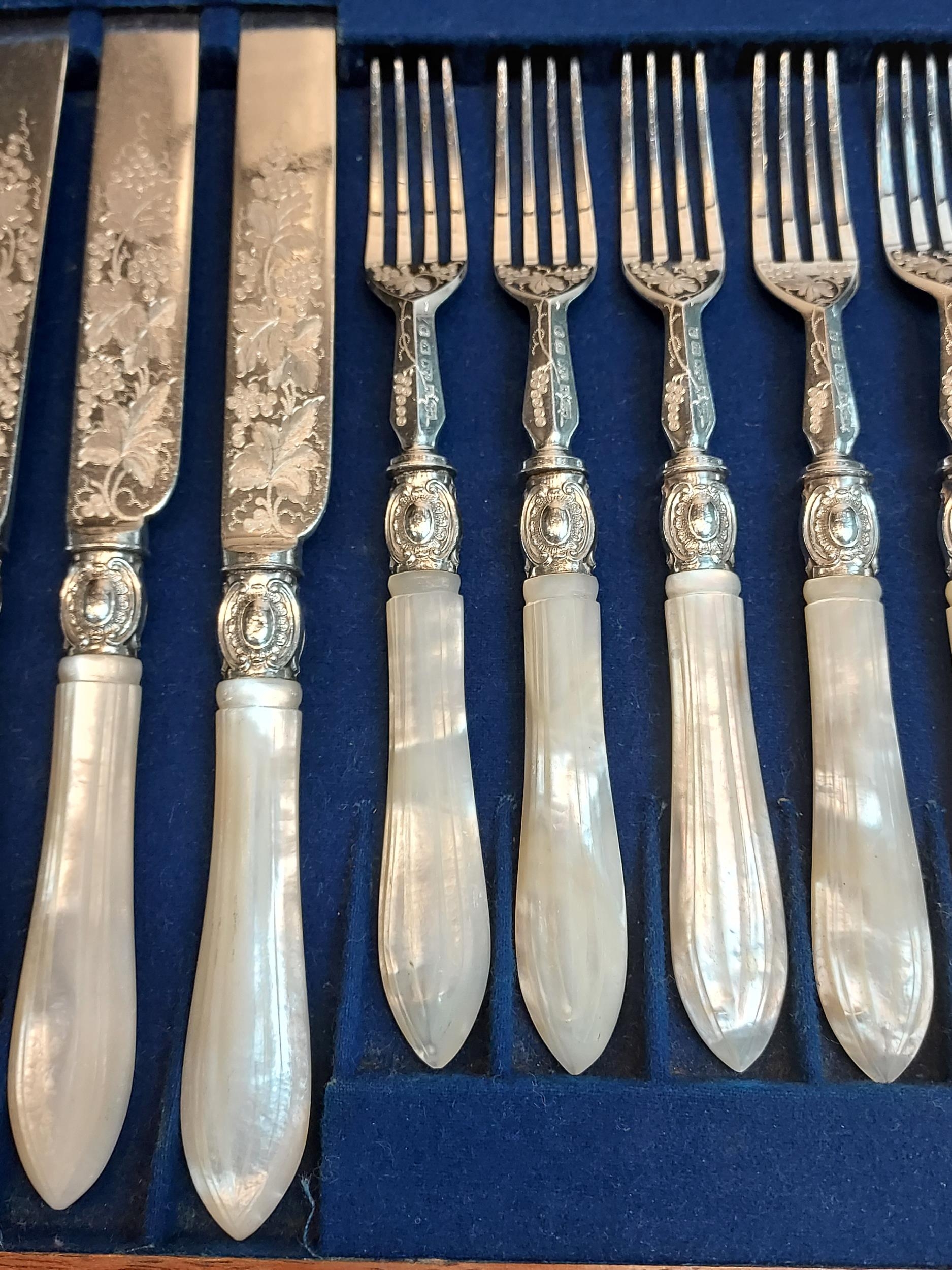 A Boxed set of twelve ornate knives and forks, designed with mother of pearl handles. - Image 3 of 3